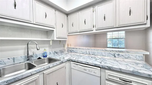 a kitchen with granite countertop a sink and cabinets