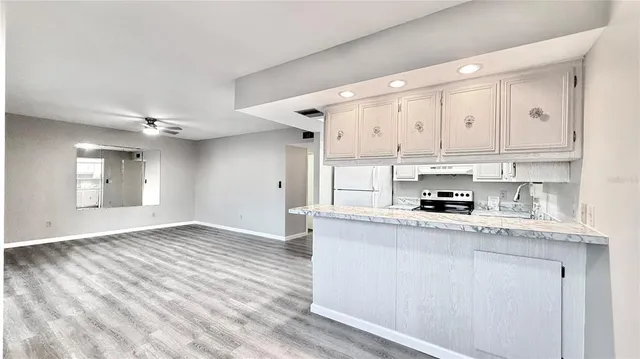 a kitchen with stainless steel appliances granite countertop a sink a stove a refrigerator and cabinets