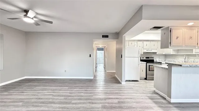 a view of kitchen with stainless steel appliances cabinets and wooden floor
