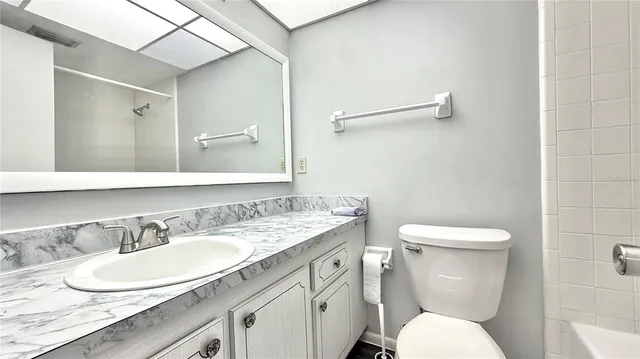 a bathroom with a granite countertop toilet sink and a mirror