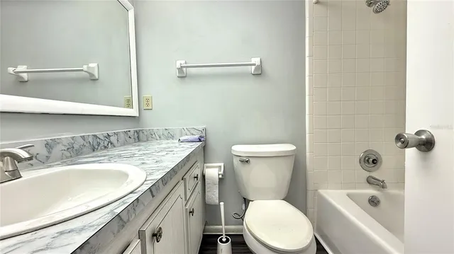 a bathroom with a granite countertop toilet sink and mirror