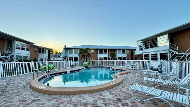 a front view of a house with swimming pool and furniture