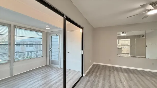 a view of an empty room with wooden floor and a window