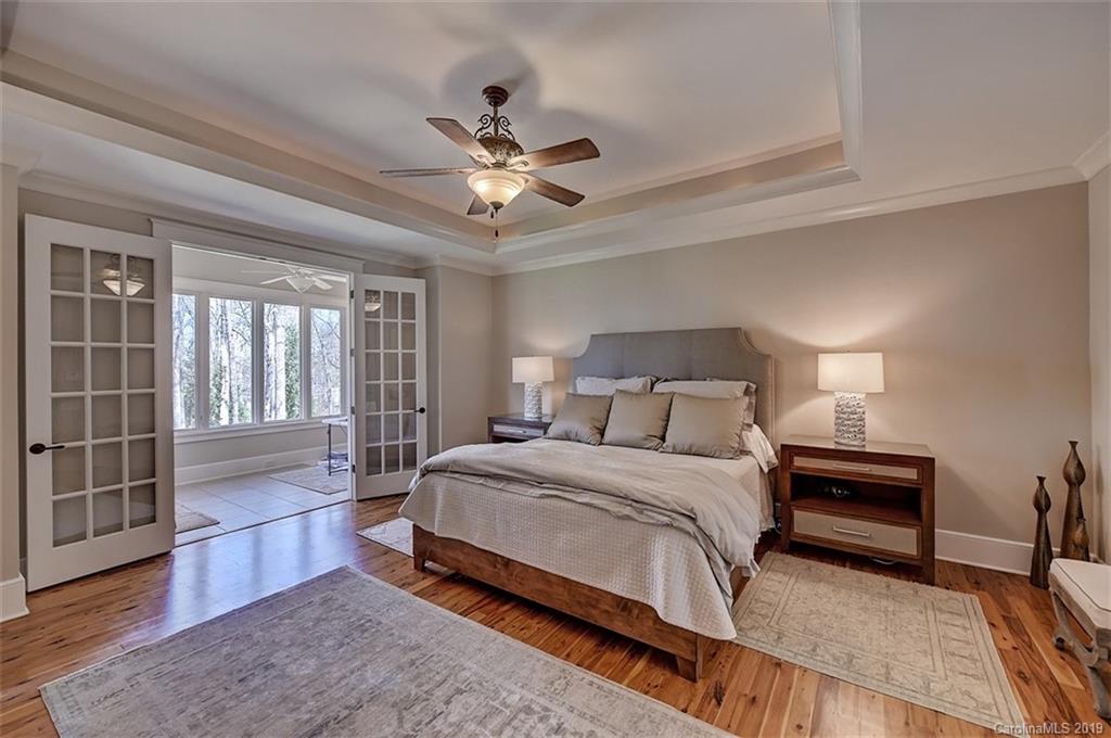 146 Dedham Loop Mooresville, NC 28117 - Photo 15 of 29 a bedroom with a large bed and a chandelier fan
