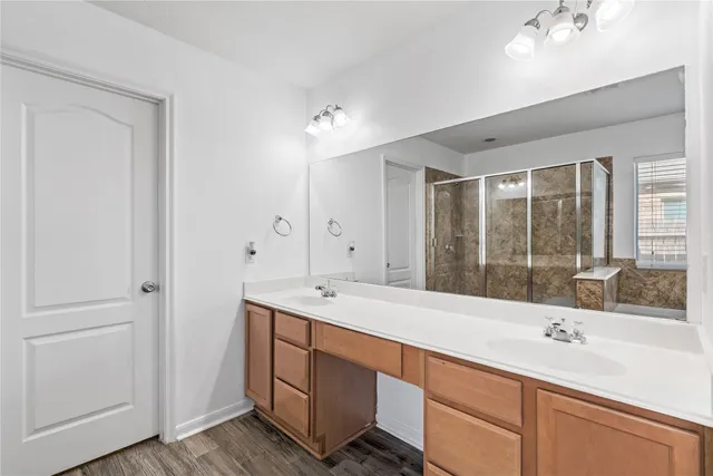 a bathroom with a sink double vanity granite tub shower and a mirror