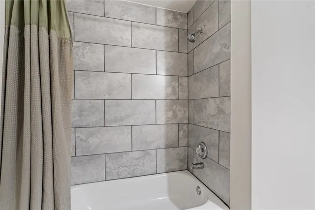 a bathroom with a tub and shower