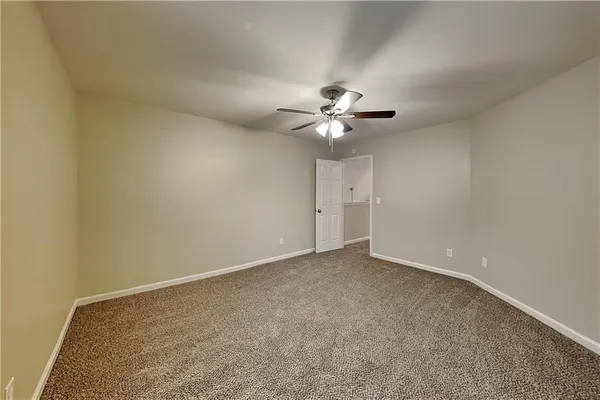 a view of an empty room with a chandelier fan