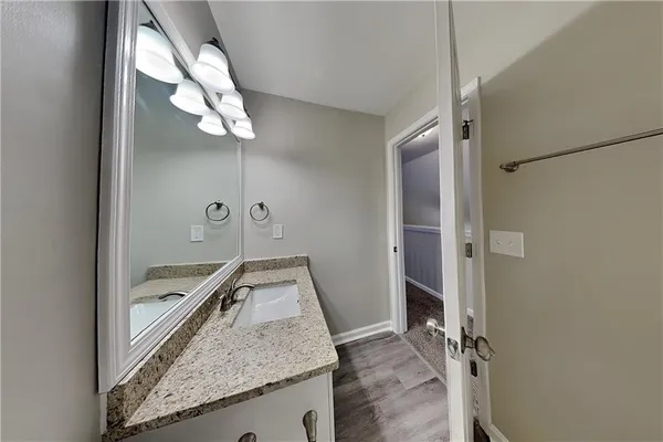 a bathroom with a granite countertop sink and a mirror