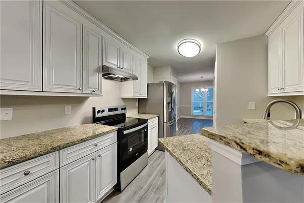 a kitchen with stainless steel appliances granite countertop a sink stove and cabinets