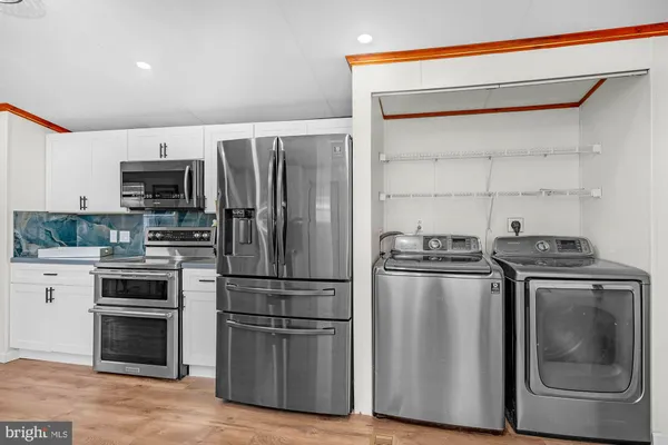 a kitchen with stainless steel appliances granite countertop a refrigerator and a stove top oven