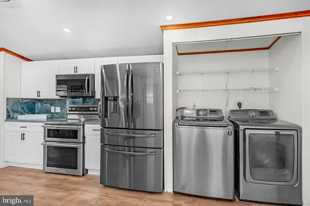 a kitchen with stainless steel appliances granite countertop a refrigerator and a stove top oven
