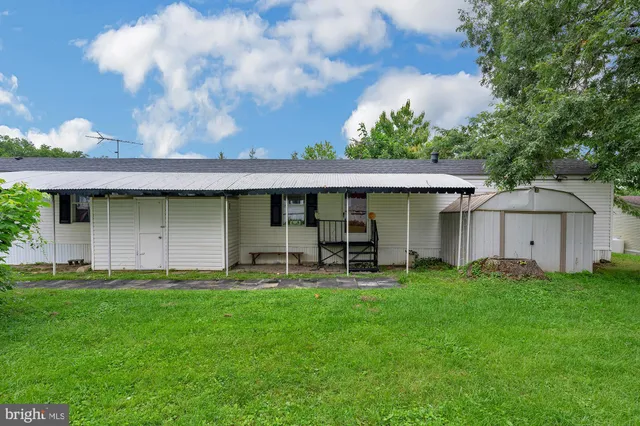 a backyard of a house with table and chairs