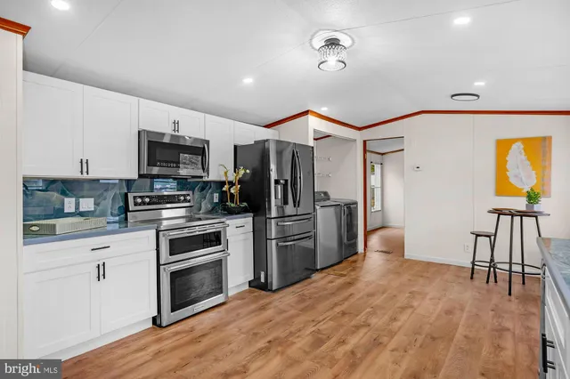 a kitchen with a sink stainless steel appliances and white cabinets