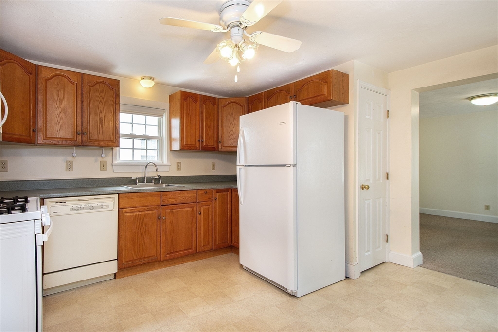 192-194 First Parish Road, Unit 1 Scituate, MA 02066 - Photo 3 of 18 a kitchen with stainless steel appliances granite countertop a refrigerator a sink a stove a microwave oven with white cabinets