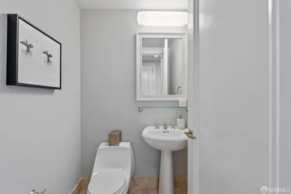 a bathroom with a sink mirror and toilet