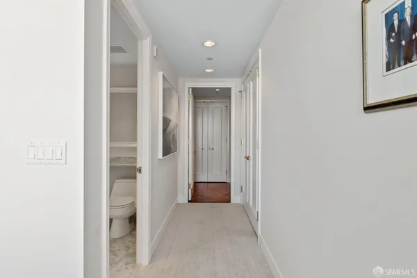 a view of a hallway with wooden shelves