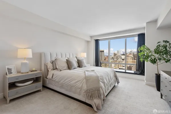 a bedroom with a large bed and a potted plant