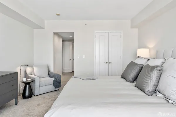 a spacious bedroom with a large bed and a potted plant