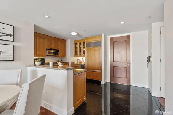 a kitchen with stainless steel appliances a refrigerator stove microwave and white cabinets