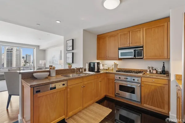 a kitchen with stainless steel appliances granite countertop a sink stove and microwave