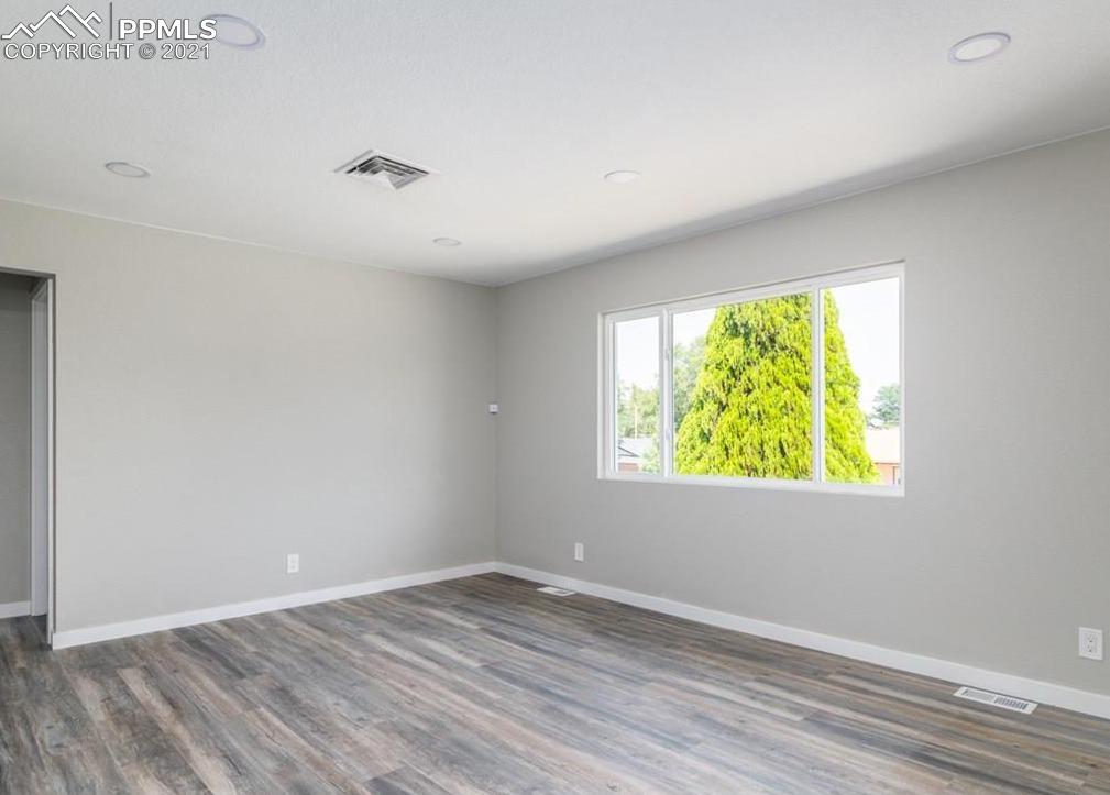 60 Calhoun Road Pueblo, CO 81001 - Photo 8 of 32 an empty room with wooden floor and windows