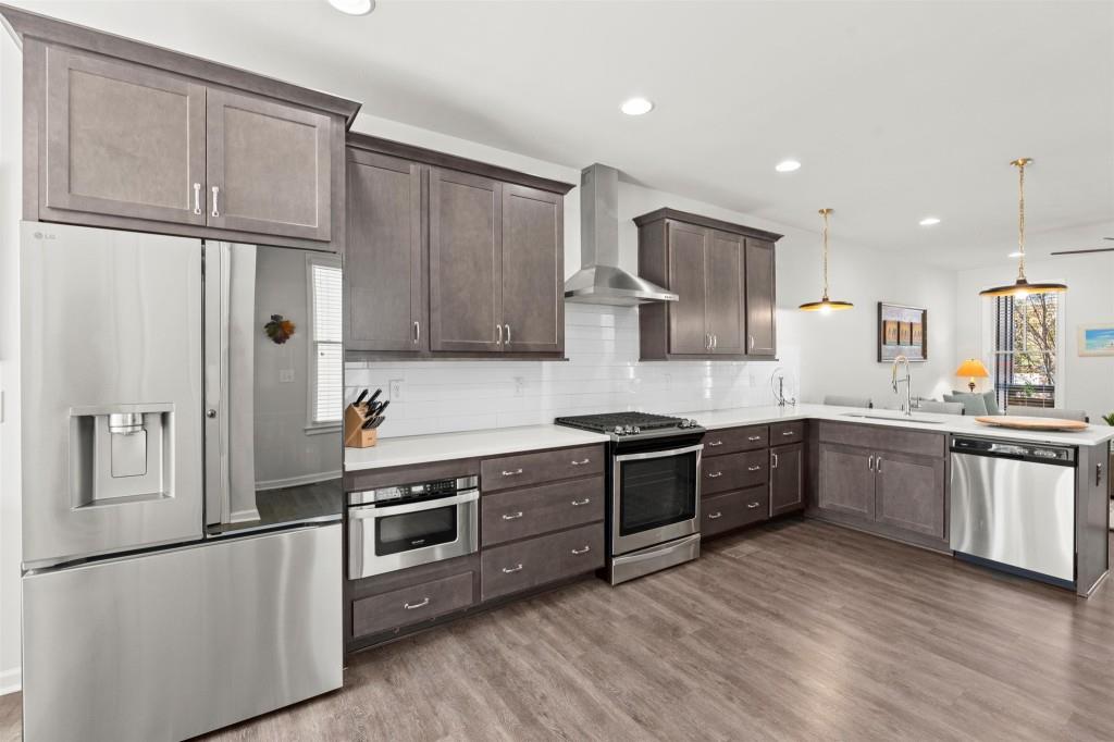 760 Aerial Way Atlanta, GA 30312 - Photo 11 of 33 a kitchen with stainless steel appliances granite countertop a refrigerator a sink dishwasher a stove and white cabinets with wooden floor