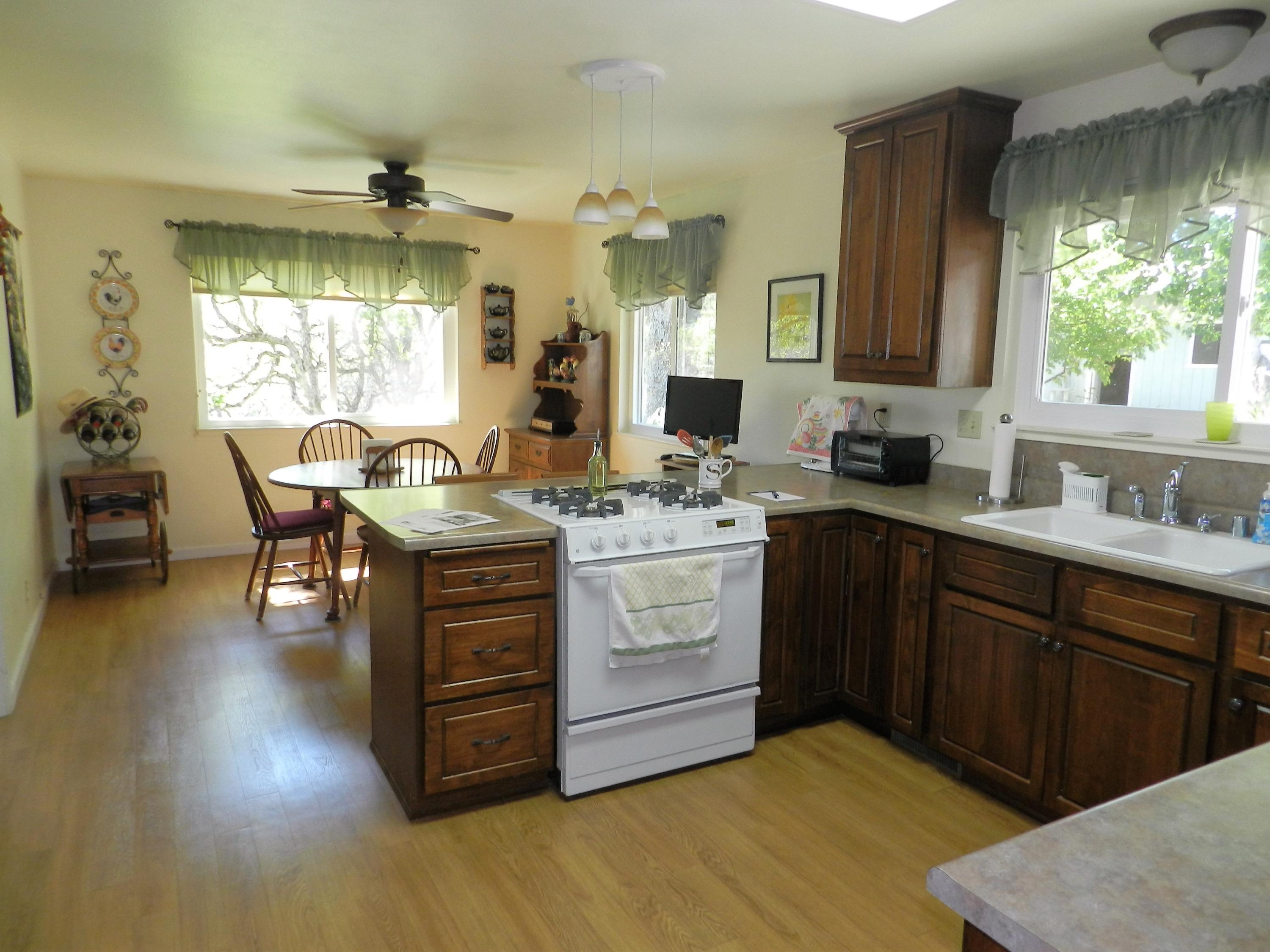 8760 Valley View Road Redding, CA 96001 - Photo 3 of 42 a kitchen with a wooden cabinets and stove