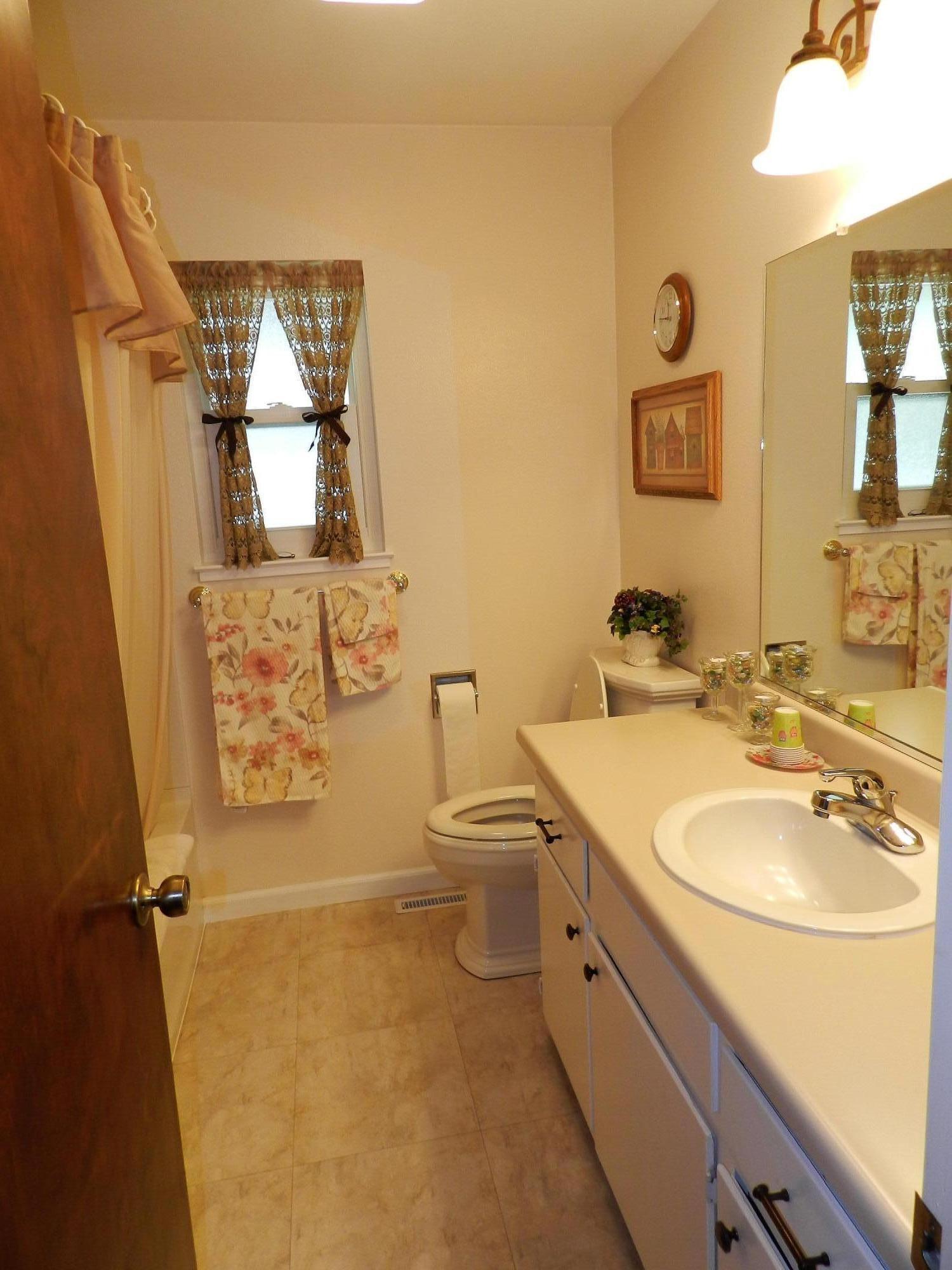 8760 Valley View Road Redding, CA 96001 - Photo 10 of 42 a bathroom with a granite countertop toilet a sink and mirror