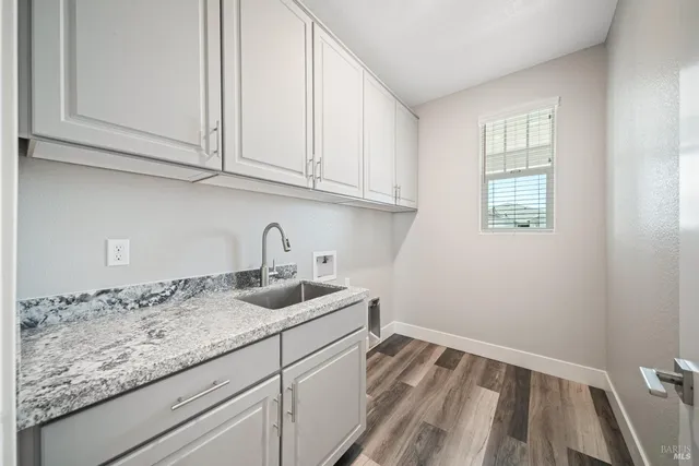 a kitchen with granite countertop white cabinets and sink