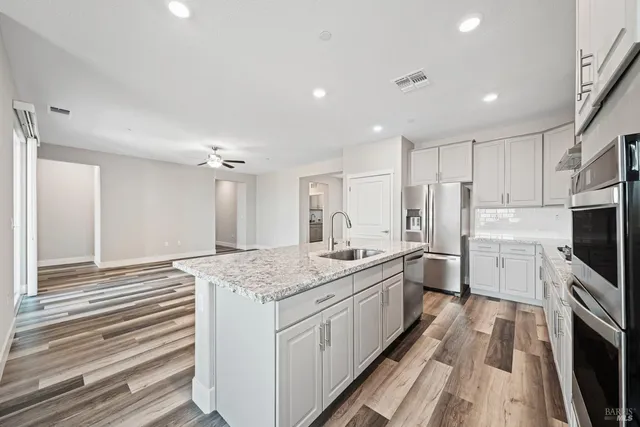 a kitchen with stainless steel appliances granite countertop a sink stove and refrigerator