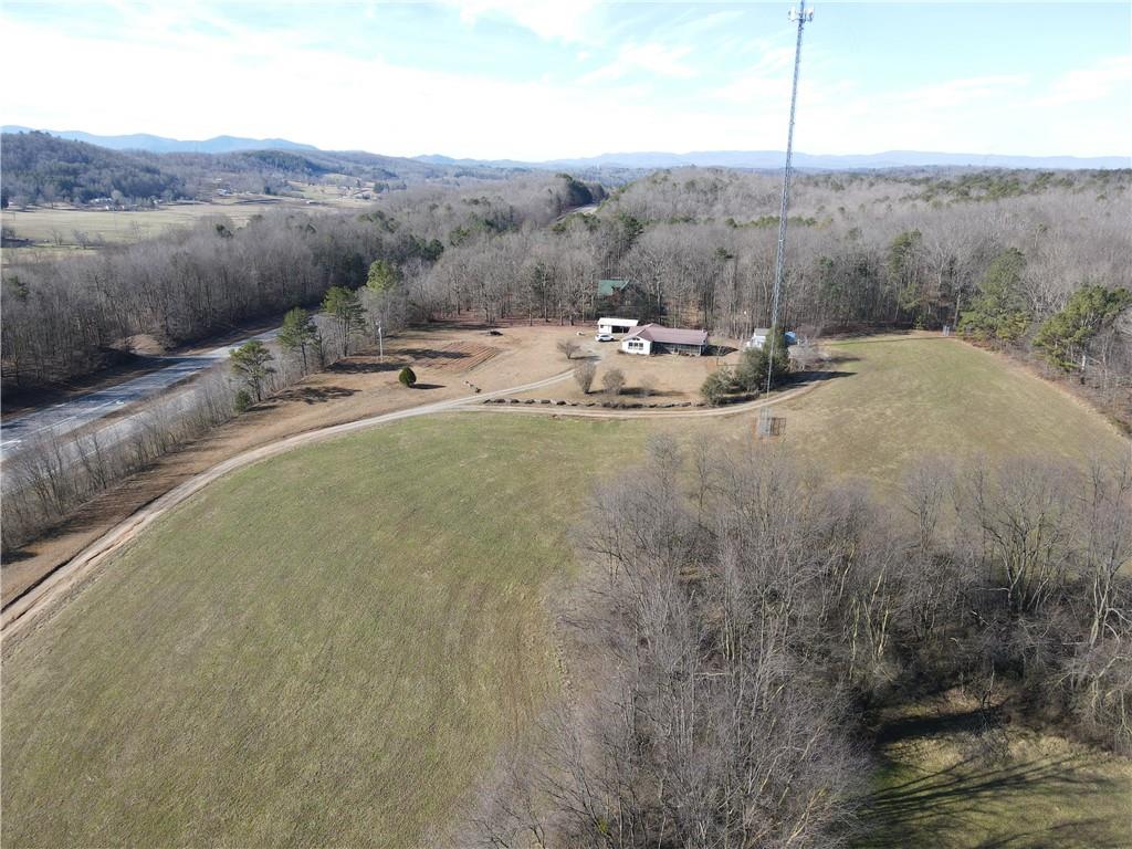 a view of a dry field with mountains in the background