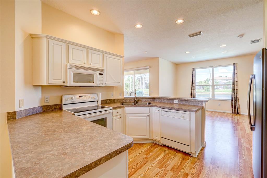 5621 52nd Avenue West Bradenton, FL 34210 - Photo 5 of 33 a kitchen with stainless steel appliances granite countertop a stove a sink and a refrigerator