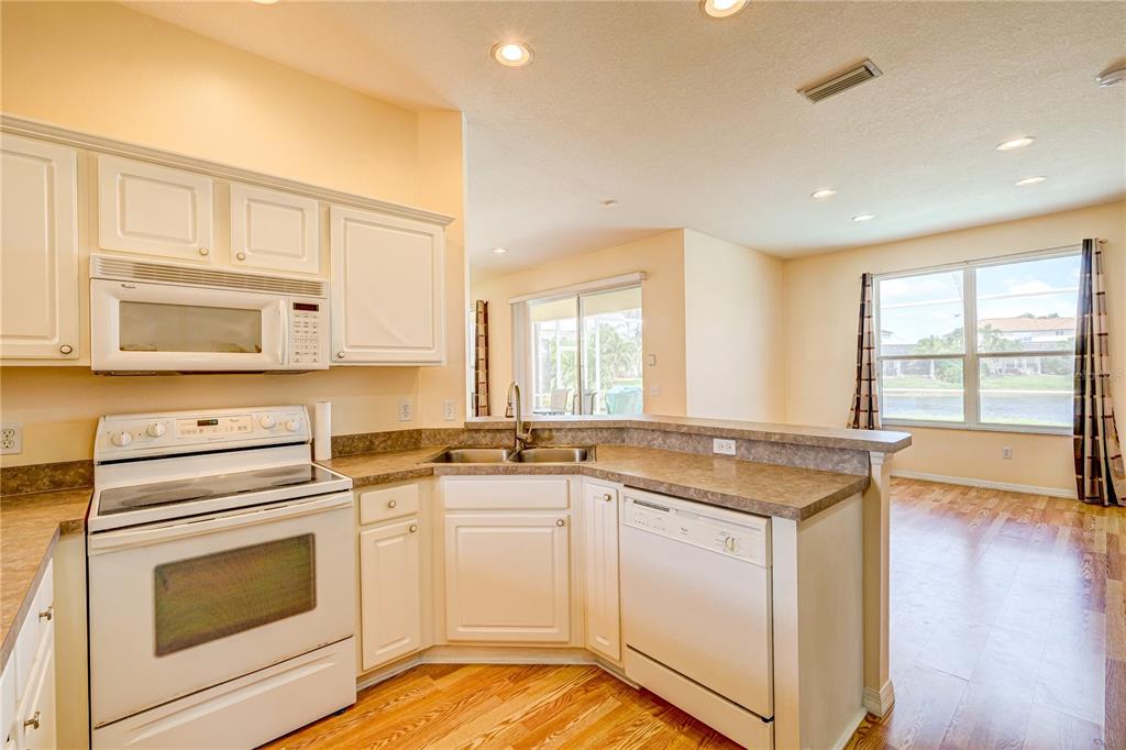 5621 52nd Avenue West Bradenton, FL 34210 - Photo 6 of 33 a kitchen with granite countertop white cabinets and white appliances