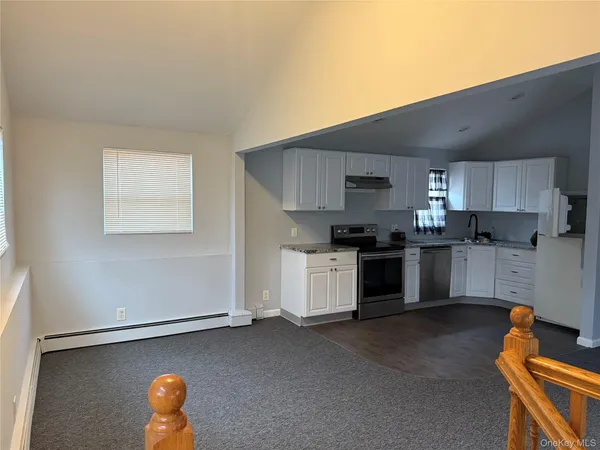 a kitchen with granite countertop a stove a sink and a refrigerator