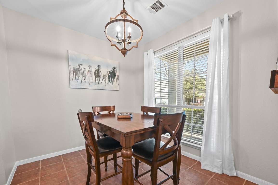 400 Tobin Drive Buda, TX 78610 - Photo 13 of 40 Dining / Breakfast room with dark tile patterned floors and a chandelier
