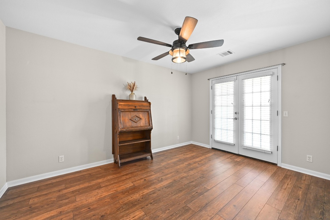 400 Tobin Drive Buda, TX 78610 - Photo 27 of 40 Spare room with wood-type flooring, ceiling fan, and French doors leading to front of house balcony.