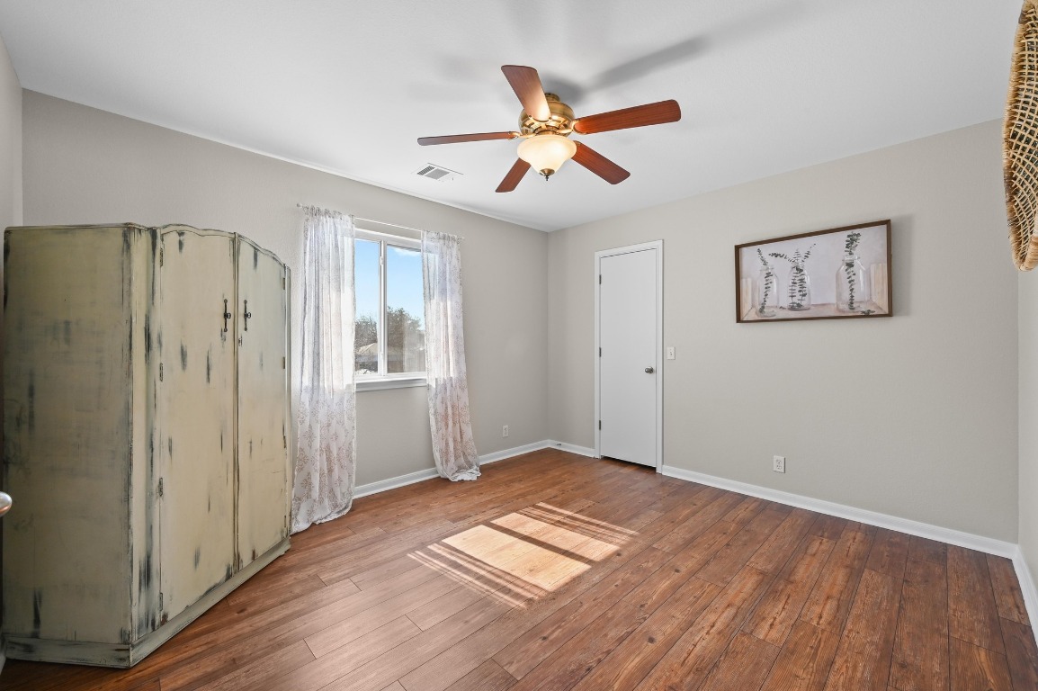 400 Tobin Drive Buda, TX 78610 - Photo 30 of 40 Unfurnished bedroom featuring ceiling fan and wood-style floors