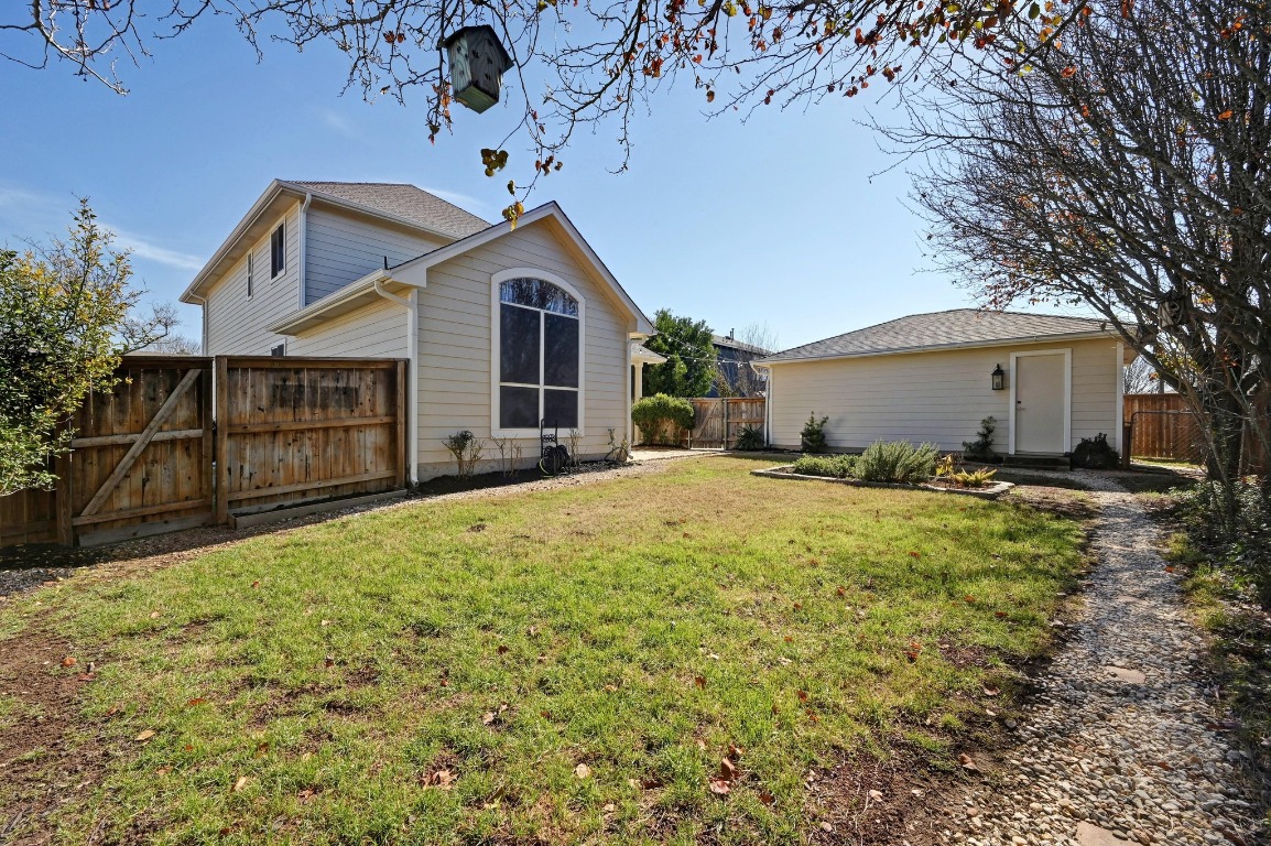 400 Tobin Drive Buda, TX 78610 - Photo 36 of 40 Rear view of house featuring a fenced backyard, a gate, and an outdoor structure