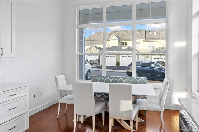 a view of a dining room with furniture large windows and wooden floor