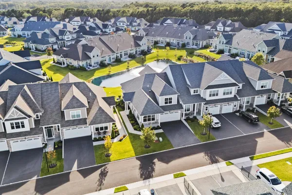 an aerial view of residential houses with swimming pool and lawn chairs