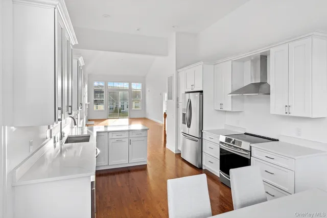 a large white kitchen with stainless steel appliances