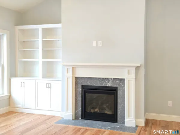 a view of an empty room with window and wooden floor