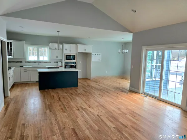 a large kitchen with cabinets wooden floor and stainless steel appliances