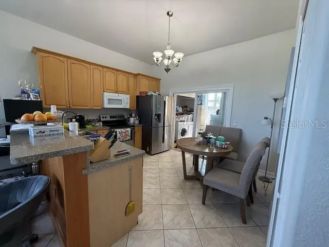 a work room with furniture a chandelier and a window