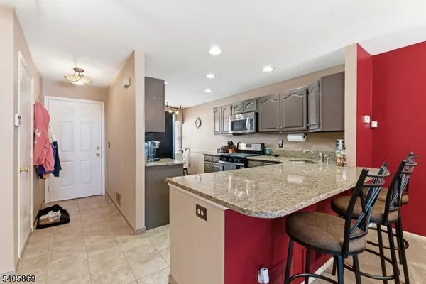 a kitchen with stainless steel appliances granite countertop a sink refrigerator and cabinets