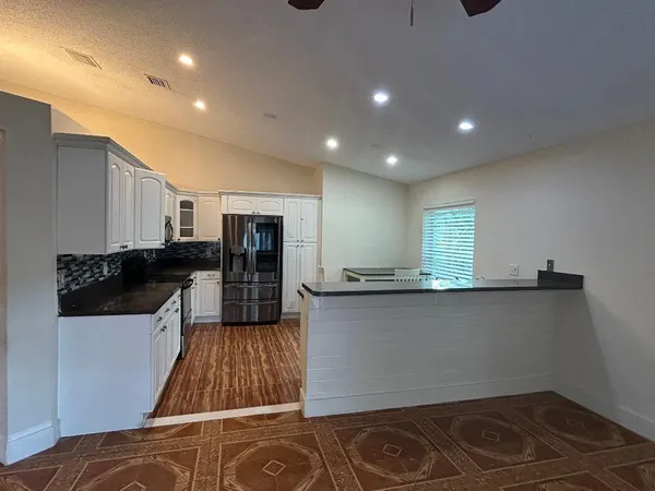 a kitchen with stainless steel appliances granite countertop a sink a stove and a refrigerator