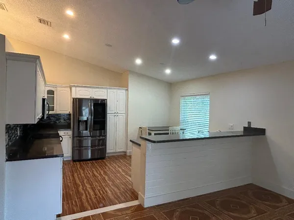 a kitchen with granite countertop a sink and a refrigerator