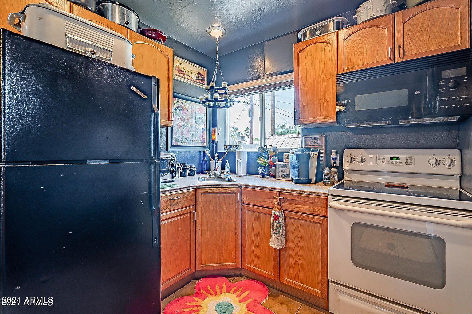 9416 North 3rd Avenue Phoenix, AZ 85021 - Photo 23 of 25 a kitchen with stainless steel appliances granite countertop a refrigerator a stove and a sink with wooden floor