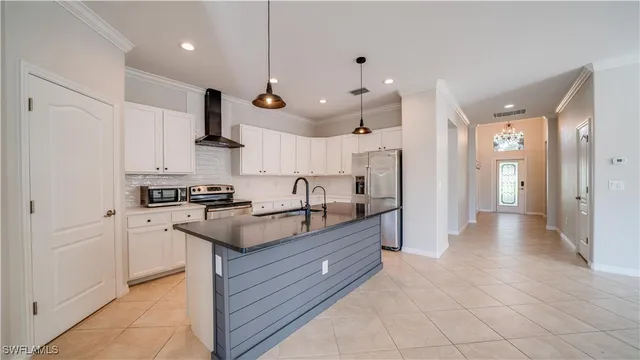 a kitchen with stainless steel appliances granite countertop a sink a stove and a refrigerator
