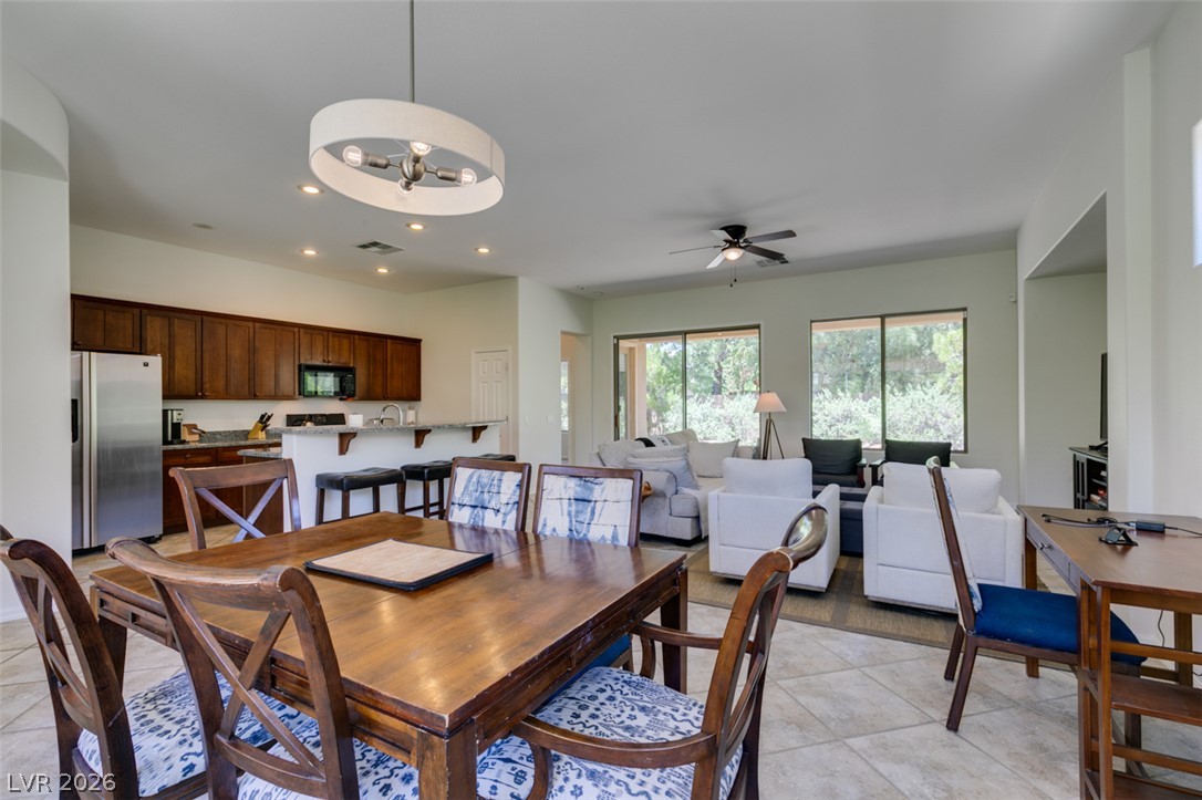 8 Kennesaw Road Henderson, NV 89052 - Photo 11 of 44 An open-concept living area features a dining space and a kitchen with rich wood cabinetry.